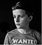 boy looking sideways down with text WANTED on T-shirt